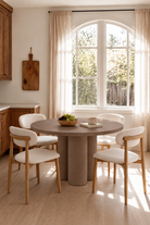 Olessa Mocha Microconcrete Round Dining Table in a warm dining room