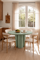Olessa Sage Green Microconcrete Round Dining Table in a warm dining room