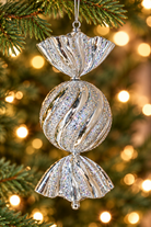 Silver glitter candy-shaped Christmas ornament with fluted wrapper ends